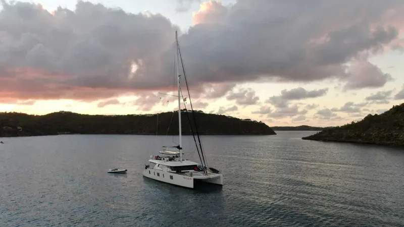 Kailua Yacht Photos Pics 2018 Sunreef 74C catamaran sailing at sunset in a tranquil bay.