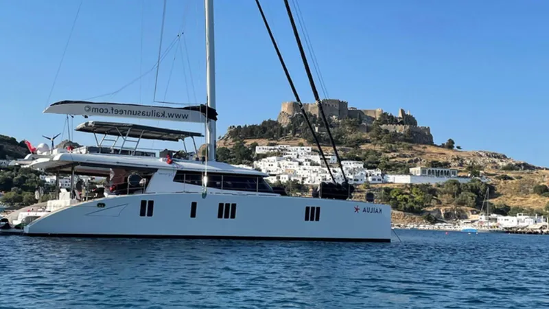 Kailua Yacht Photos Pics Luxury Sunreef 74C catamaran sailing near a historic coastal fortress, 2018 model.