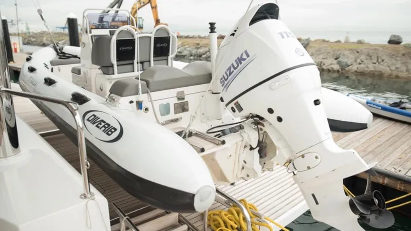 Kailua Yacht Photos Pics Inflatable boat with Suzuki outboard motor on Sunreef 74C yacht, docked at marina.