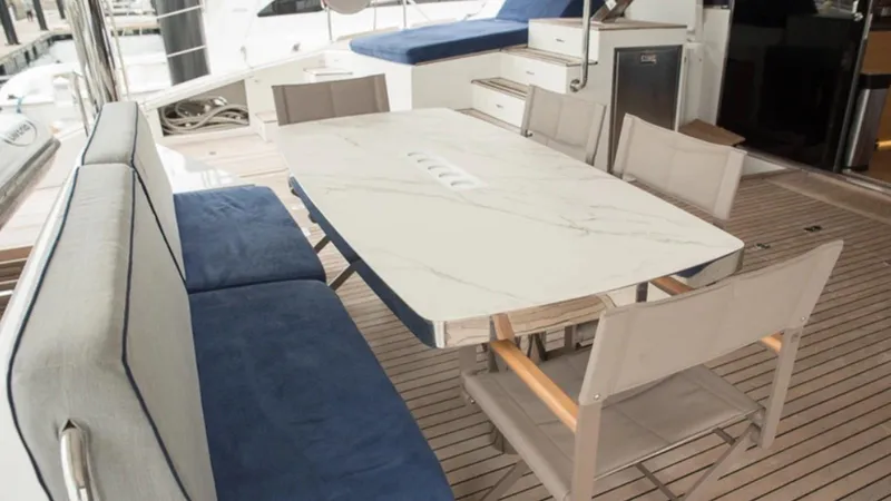 Kailua Yacht Photos Pics Outdoor dining area on 2018 Sunreef 74C yacht with marble table and cushioned seating.