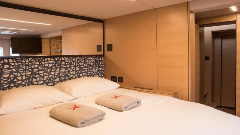 Kailua Yacht Photos Pics Luxurious bedroom interior of 2018 Sunreef 74C yacht with modern decor and cozy bedding.