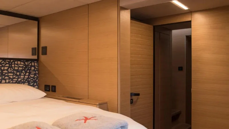 Kailua Yacht Photos Pics Luxurious Sunreef 74C 2018 yacht cabin with modern wood paneling and cozy bedding.