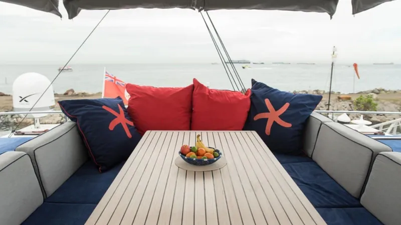 Kailua Yacht Photos Pics Luxurious Sunreef 74C yacht deck with cozy seating, vibrant cushions, and a fruit bowl centerpiece.