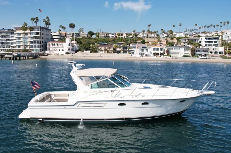 Gina Marie Yacht Photos Pics 1997 Tiara Yachts 3700 Open cruising near a scenic coastal area with beachfront homes.