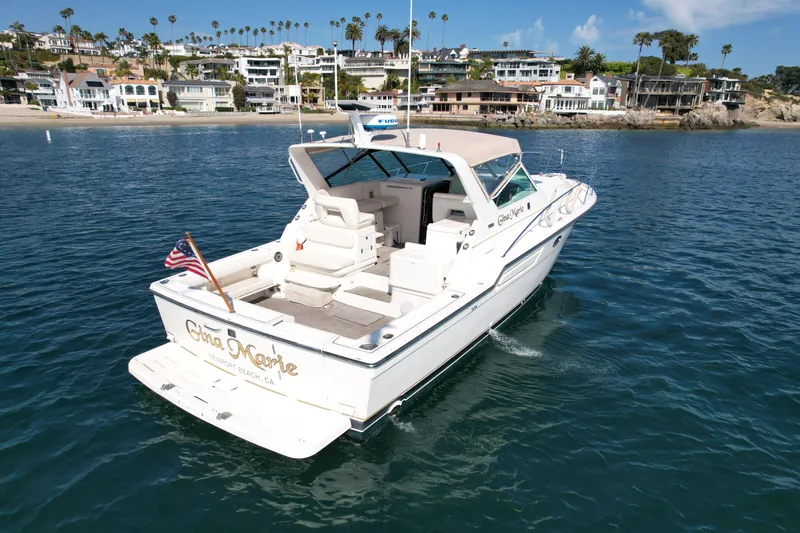 Gina Marie Yacht Photos Pics 1997 Tiara Yachts 3700 Open cruising near a coastal residential area.