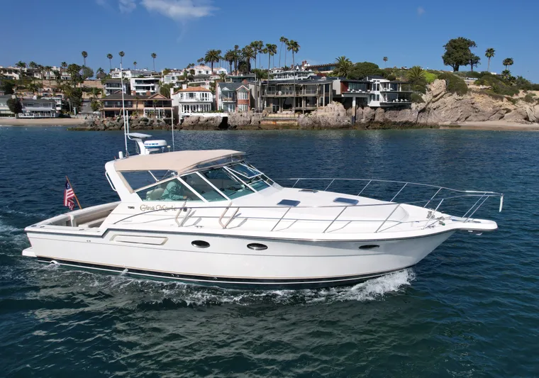 Gina Marie Yacht Photos Pics 1997 Tiara Yachts 3700 Open cruising near coastal homes, under clear blue skies.