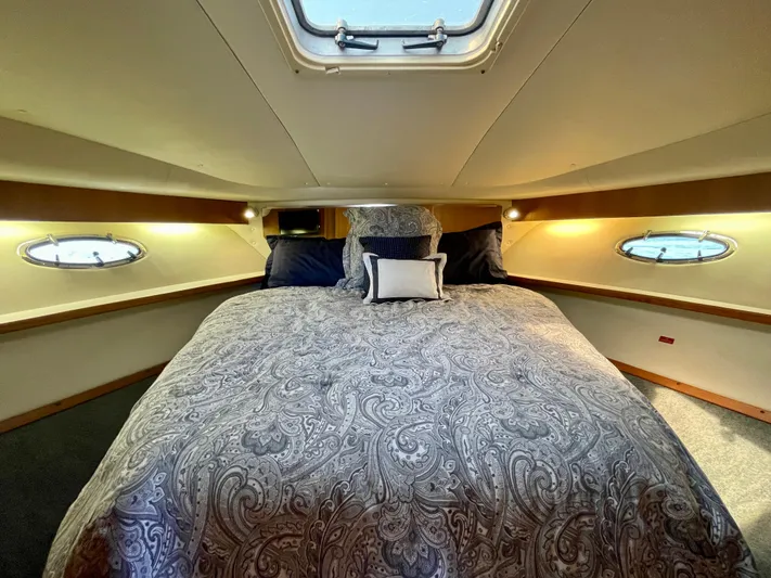 Gina Marie Yacht Photos Pics Luxurious cabin interior of 1997 Tiara Yachts 3700 Open with elegant bedding and porthole windows.