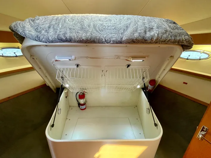 Gina Marie Yacht Photos Pics 1997 Tiara Yachts 3700 Open cabin storage with bed lifted, revealing spacious compartment.