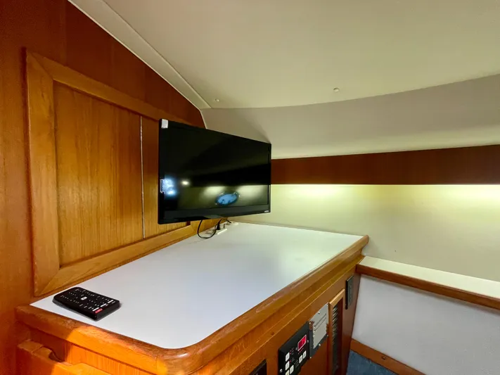 Gina Marie Yacht Photos Pics 1997 Tiara Yachts 3700 Open interior with TV and remote on wooden cabinet.