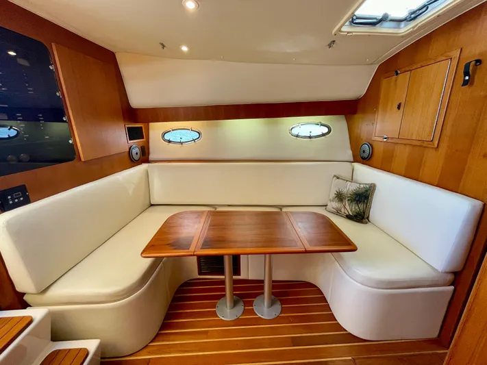 Gina Marie Yacht Photos Pics 1997 Tiara Yachts 3700 Open interior with white seating and wooden table.