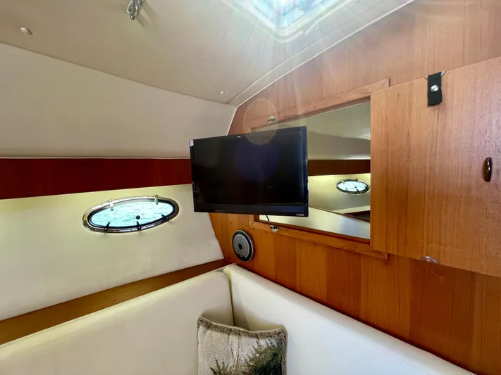 Gina Marie Yacht Photos Pics Interior of 1997 Tiara Yachts 3700 Open with TV, porthole, and wooden cabinetry.