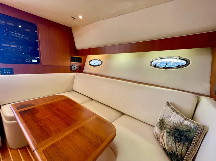 Gina Marie Yacht Photos Pics 1997 Tiara Yachts 3700 Open interior with white seating, wooden table, and porthole windows.