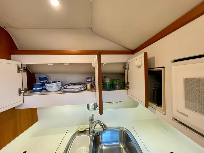 Gina Marie Yacht Photos Pics 1997 Tiara Yachts 3700 Open kitchen with open cabinets, sink, and microwave.