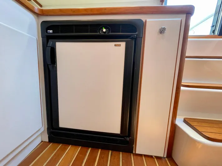 Gina Marie Yacht Photos Pics 1997 Tiara Yachts 3700 Open interior with compact fridge and wooden flooring.