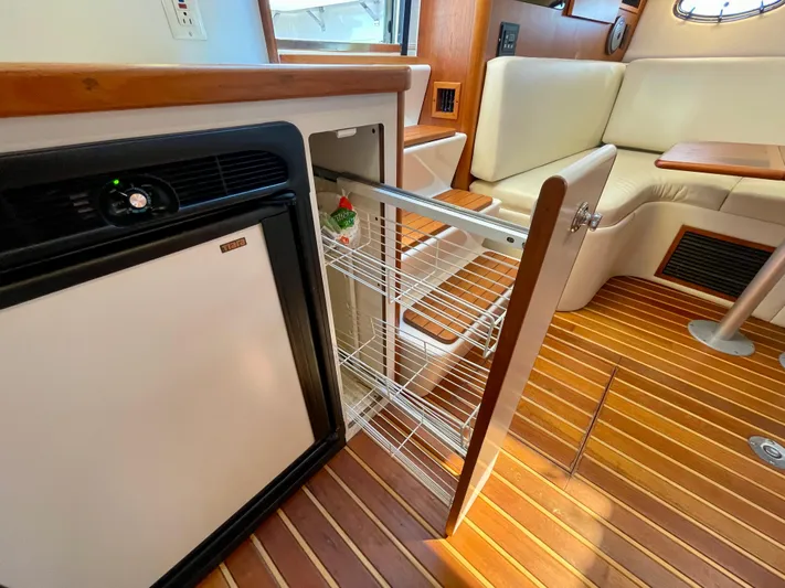 Gina Marie Yacht Photos Pics 1997 Tiara Yachts 3700 Open interior with fridge, pull-out storage, and wooden flooring.