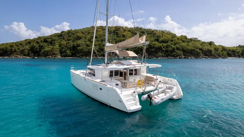 Altair Yacht Photos Pics 2018 Lagoon 450 F catamaran anchored in turquoise waters near a lush island.