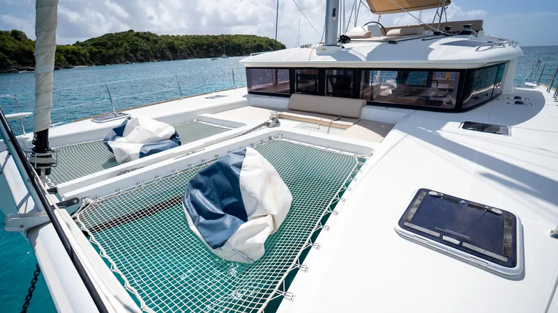 Altair Yacht Photos Pics 2018 Lagoon 450 F catamaran with netted deck, anchored in clear blue waters.