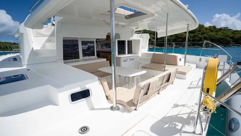 Altair Yacht Photos Pics Luxurious 2018 Lagoon 450 F catamaran with spacious deck and seating area, docked by turquoise waters.