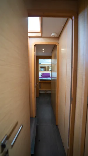 Altair Yacht Photos Pics Interior hallway of 2018 Lagoon 450 F yacht, featuring modern wood paneling and cozy cabin view.