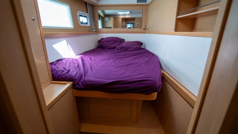 Altair Yacht Photos Pics Cabin interior of 2018 Lagoon 450 F yacht with purple bedding and wooden finish.