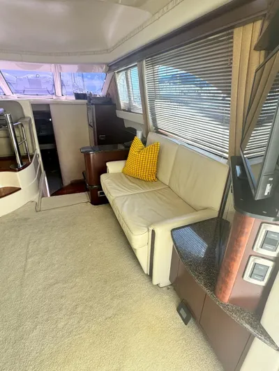  Yacht Photos Pics Interior of 2007 Sea Ray 44 Sedan Bridge with sofa, yellow pillow, and large windows.