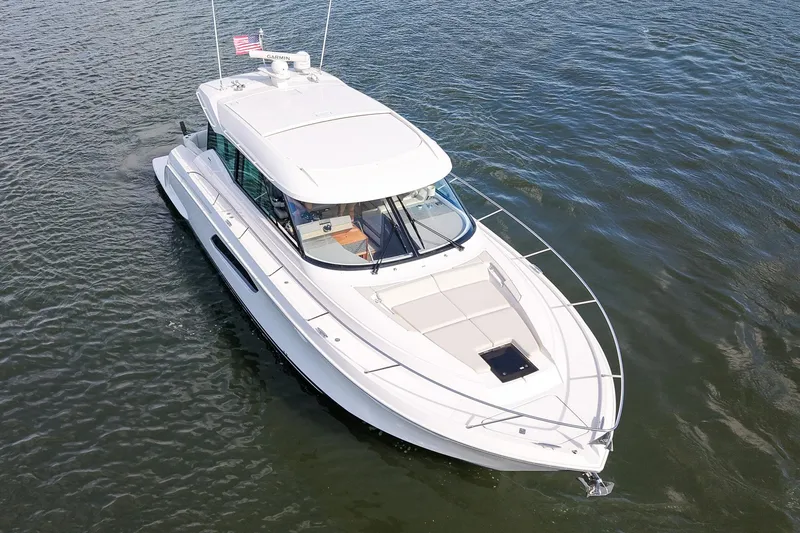  Yacht Photos Pics 2019 Tiara Yachts C49 Coupe cruising on open water, aerial view.