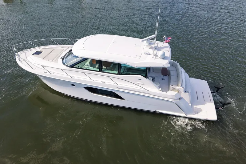  Yacht Photos Pics 2019 Tiara Yachts C49 Coupe cruising on water, sleek design, luxury motor yacht.