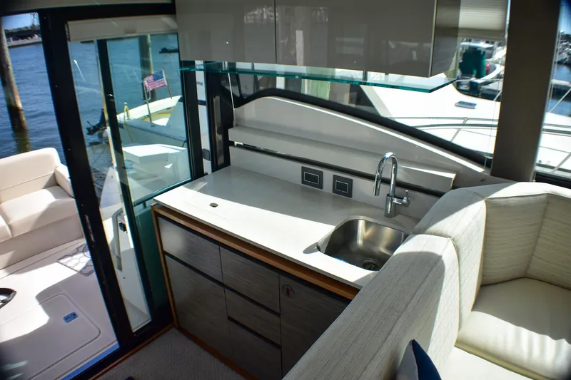  Yacht Photos Pics Interior of 2019 Tiara Yachts C49 Coupe, featuring a sleek kitchenette and seating area.