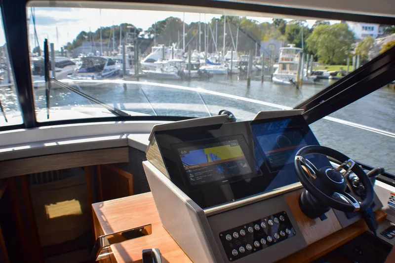  Yacht Photos Pics 2019 Tiara Yachts C49 Coupe helm with navigation screens, overlooking marina.