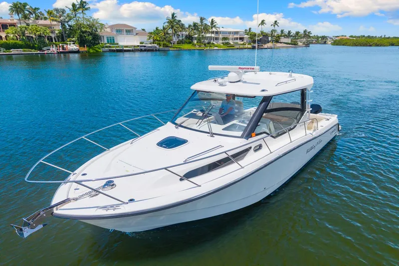  Yacht Photos Pics 2021 Boston Whaler 325 Conquest boat cruising on a scenic waterway.