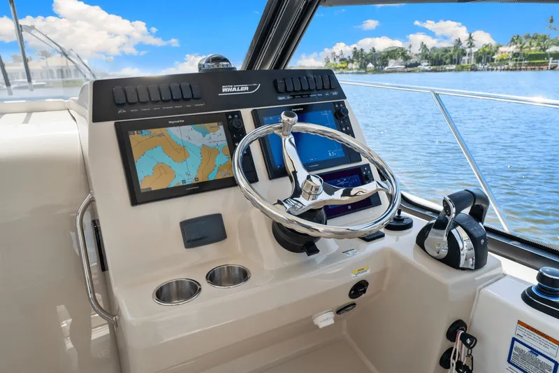  Yacht Photos Pics 2021 Boston Whaler 325 Conquest helm with navigation screens and steering wheel.