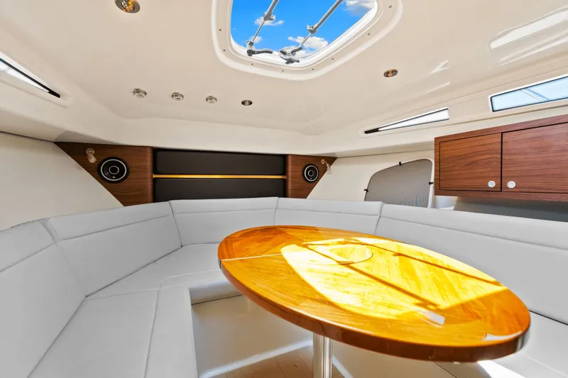  Yacht Photos Pics Luxurious interior of 2021 Boston Whaler 325 Conquest with elegant seating and wooden table.