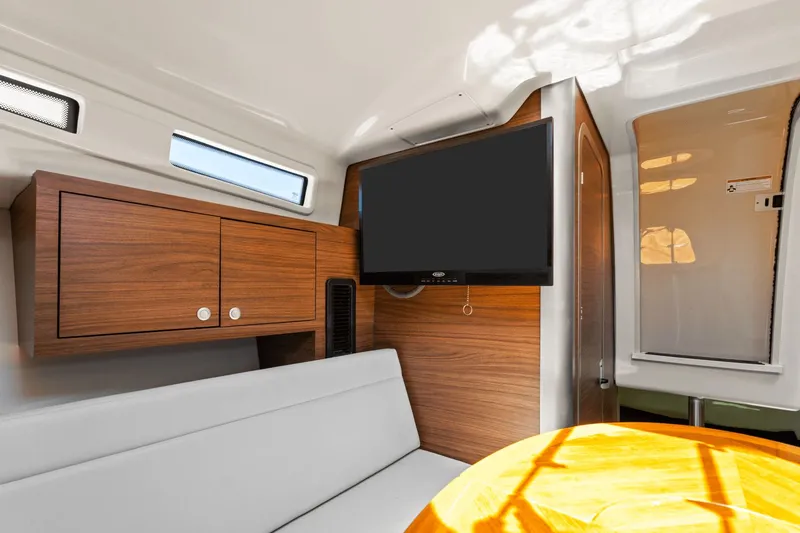  Yacht Photos Pics Interior of 2021 Boston Whaler 325 Conquest with TV, wooden cabinets, and seating area.