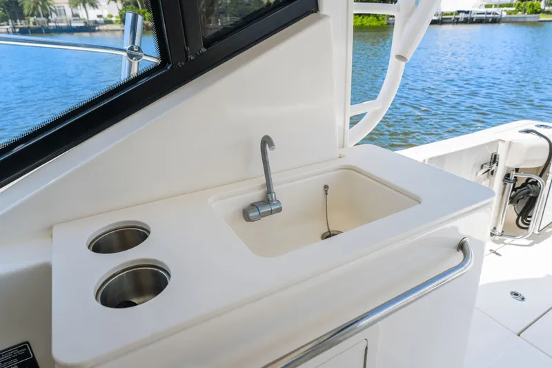  Yacht Photos Pics 2021 Boston Whaler 325 Conquest boat sink and cup holders by the water.