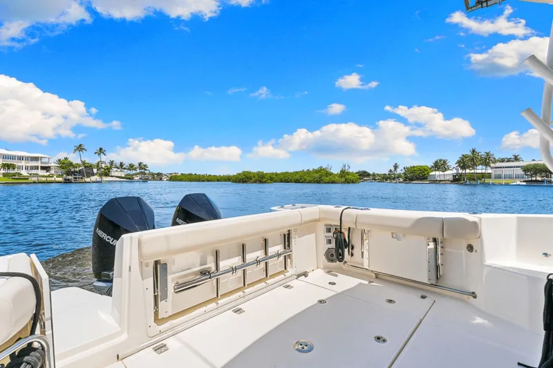  Yacht Photos Pics 2021 Boston Whaler 325 Conquest boat on a sunny waterfront with palm trees.