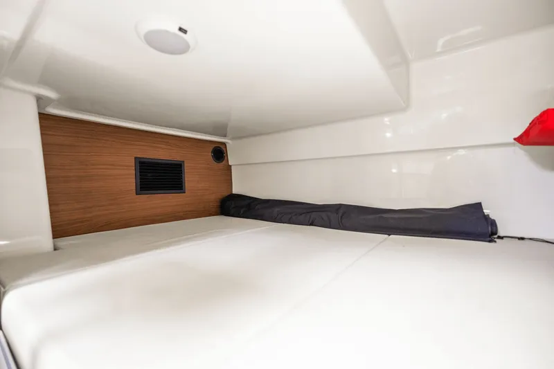  Yacht Photos Pics 2021 Boston Whaler 325 Conquest cabin interior with wood paneling and white upholstery.