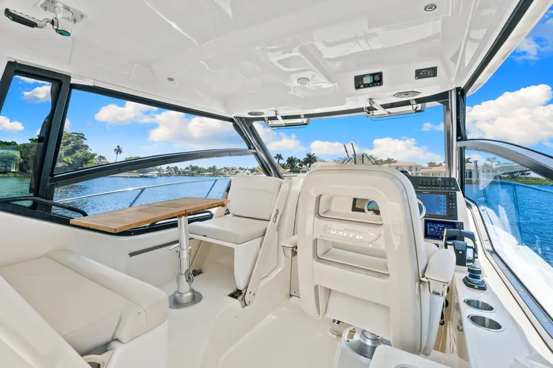  Yacht Photos Pics 2021 Boston Whaler 325 Conquest interior with helm, seating, and water view.
