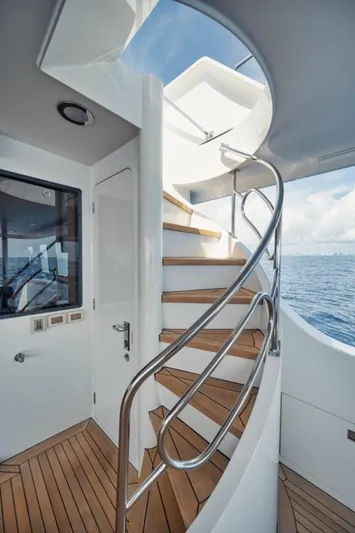 Island Girl Yacht Photos Pics Elegant spiral staircase on 2002 Westport 112 yacht, featuring teak steps and ocean view.