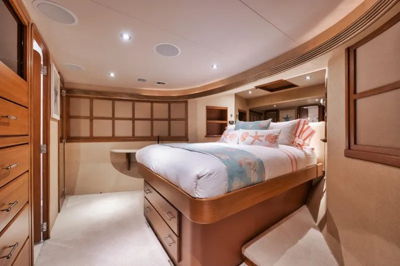 Island Girl Yacht Photos Pics Luxurious bedroom interior on 2002 Westport 112 yacht, featuring elegant wood finishes and cozy bedding.