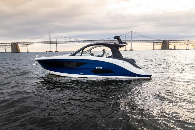 Nauti Tiger Yacht Photos Pics 2024 Sea Ray Sundancer 370 yacht cruising near a bridge at sunset.