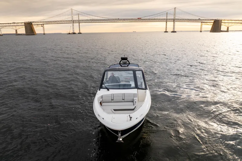 Nauti Tiger Yacht Photos Pics 2024 Sea Ray Sundancer 370 cruising near a large bridge at sunset.