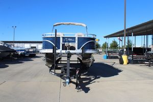 2025 Sun Tracker Fishin' Barge 22 DLX pontoon boat on trailer in marina.