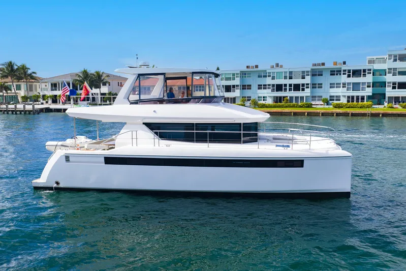 Better Now Yacht Photos Pics 2023 Leopard 46 Powercat yacht cruising near waterfront homes.