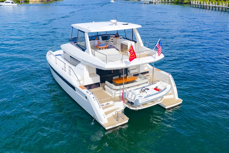 Better Now Yacht Photos Pics 2023 Leopard 46 Powercat yacht cruising on blue water, featuring spacious deck and flags.
