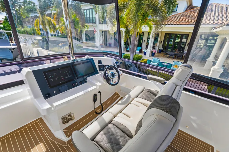 Better Now Yacht Photos Pics 2023 Leopard 46 Powercat helm with modern controls, luxurious seating, and waterfront view.