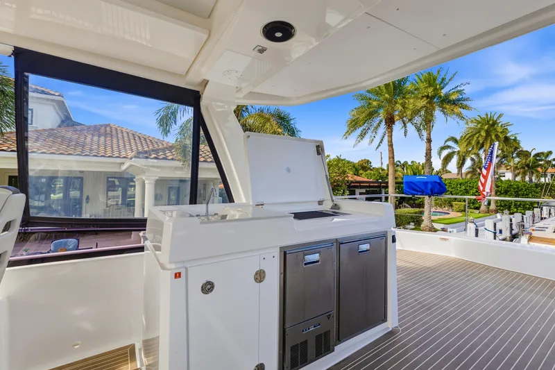 Better Now Yacht Photos Pics Luxurious 2023 Leopard 46 Powercat yacht deck with outdoor kitchen and scenic view.
