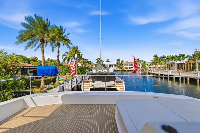 Better Now Yacht Photos Pics 2023 Leopard 46 Powercat yacht docked in a scenic waterfront location with palm trees.