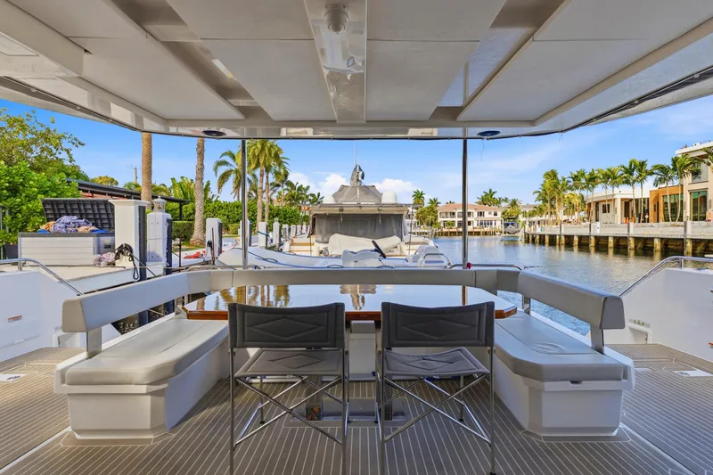 Better Now Yacht Photos Pics 2023 Leopard 46 Powercat yacht interior with seating, table, and waterfront view.