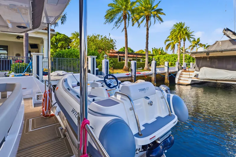 Better Now Yacht Photos Pics 2023 Leopard 46 Powercat docked with Turbojet tender, surrounded by palm trees.