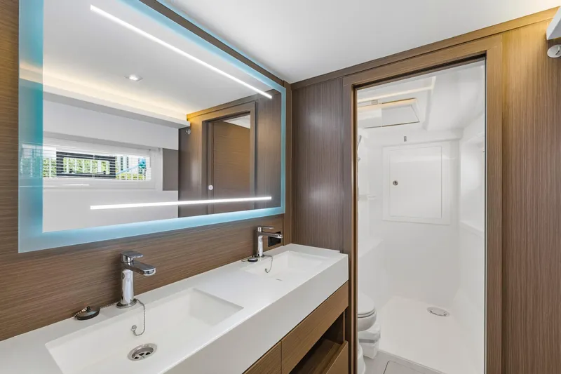 Better Now Yacht Photos Pics Modern bathroom in 2023 Leopard 46 Powercat yacht with dual sinks and illuminated mirror.